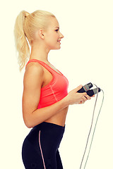 Image showing smiling sporty woman with with skipping rope