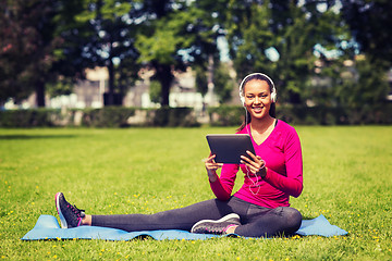 Image showing smiling woman with tablet pc outdoors