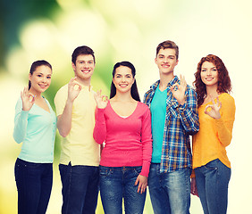 Image showing group of smiling teenagers over green background