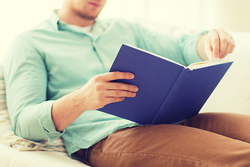 Image showing close up of man reading book at home