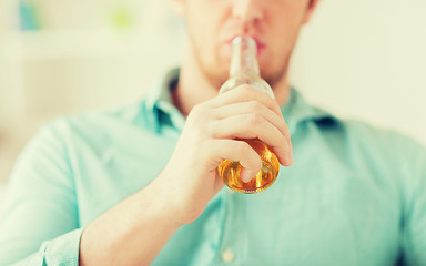 Image showing close up of man drinking beer at home