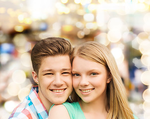 Image showing smiling couple hugging over lights background