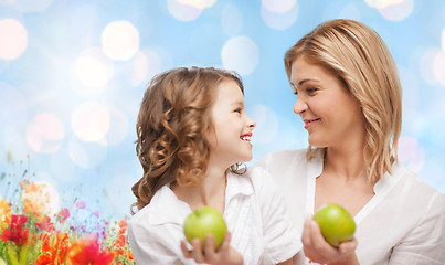 Image showing happy mother and daughter with green apples