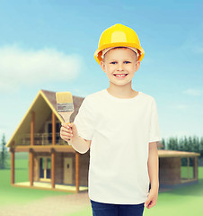 Image showing smiling little boy in helmet with paint brush