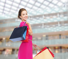 Image showing young happy woman with shopping bags over lights