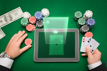 Image showing casino poker player with cards, tablet and chips