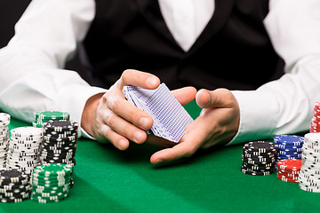 Image showing holdem dealer with playing cards and casino chips