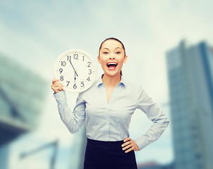 Image showing attractive businesswoman with wall clock