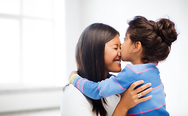 Image showing happy little girl hugging and kissing her mother