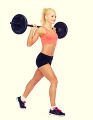 Image showing smiling sporty woman exercising with barbell