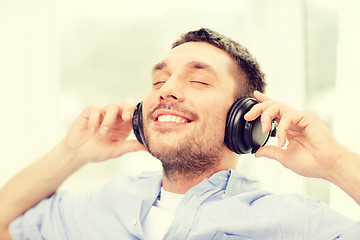 Image showing smiling young man in headphones at home