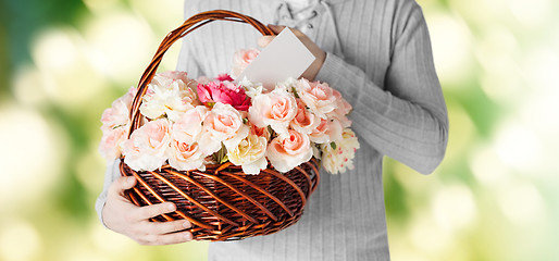 Image showing man holding basket full of flowers and postcard