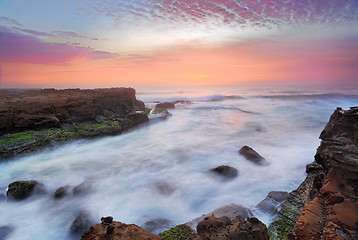 Image showing Stunning sunrise and ocean flows over tidal rocks