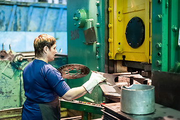 Image showing Woman stamps details on hydraulic press