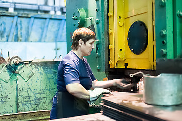 Image showing Senior woman stamps details on hydraulic press