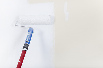 Image showing Paint roller on white wall