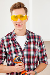 Image showing smiling repairman with a dril