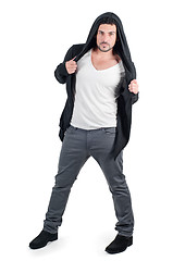 Image showing Young man in black hooded jacket poses at studio