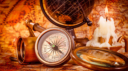 Image showing Vintage magnifying glass lies on an ancient world map