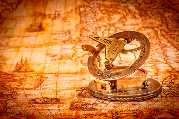 Image showing Vintage compass lies on an ancient world map.