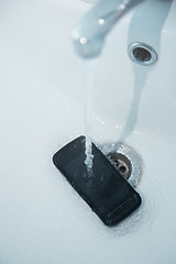 Image showing Smartphone in sink with flowing water