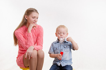 Image showing Mom watches her son to blow bubbles