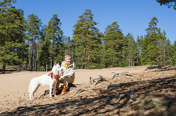 Image showing The woman with a white dog in a wood