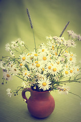 Image showing Bouquet of wild flowers in a clay pot, close-up  