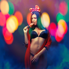 Image showing attractive girl in colorful light party with lolly