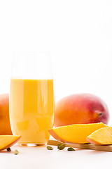 Image showing Glass Of Mango Lassi And Cut Fruit Pulp On White
