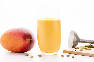 Image showing One Glass Of Mango Lassi And A Whole Fruit