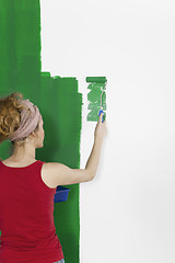 Image showing A woman painting wall green