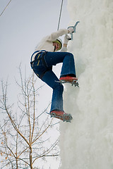 Image showing Girl climbs upward on ice climbing competition