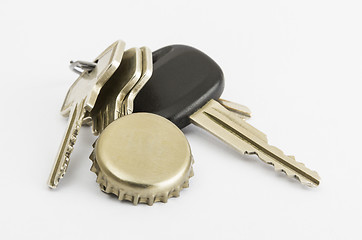 Image showing car key and bottle cap in close up