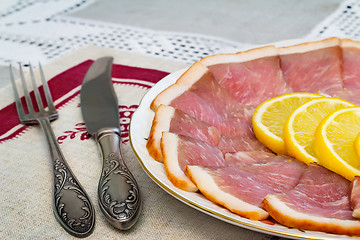Image showing The dish with slices of ham and lemon 