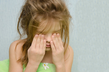 Image showing Awakened girl rubbing sleepy eyes
