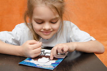 Image showing The girl at the table playing sand applique