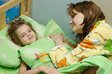 Image showing Mom wakes up her daughter in the morning