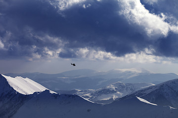 Image showing Off-piste slope for heliskiing and helicopter in evening mountai