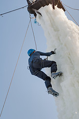 Image showing Man climbs upward on ice climbing competition