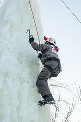 Image showing Man climbs upward on ice climbing competition