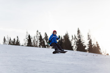 Image showing Young boy riding snowboard