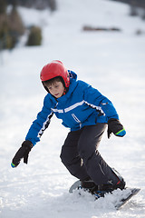Image showing Young boy riding snowboard