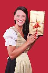 Image showing Young woman with dirndl and a great gift in hand