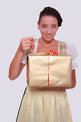 Image showing Young woman in Bavarian Dirndl grabs a gift from