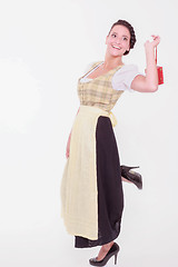 Image showing Young Bavarian woman in dirndl holds a small packet with a finger over the shoulder