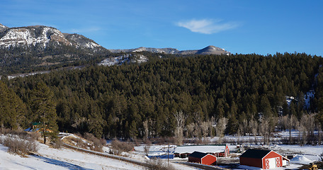 Image showing Red house under the snow mountain in the winter