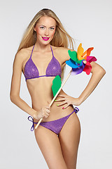 Image showing Female in lilac bikini with colorful windmill
