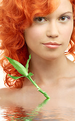 Image showing lovely redhead with bamboo in water