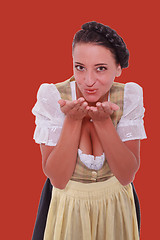 Image showing Young Bavarian woman in dirndl breathed on palms of your hands